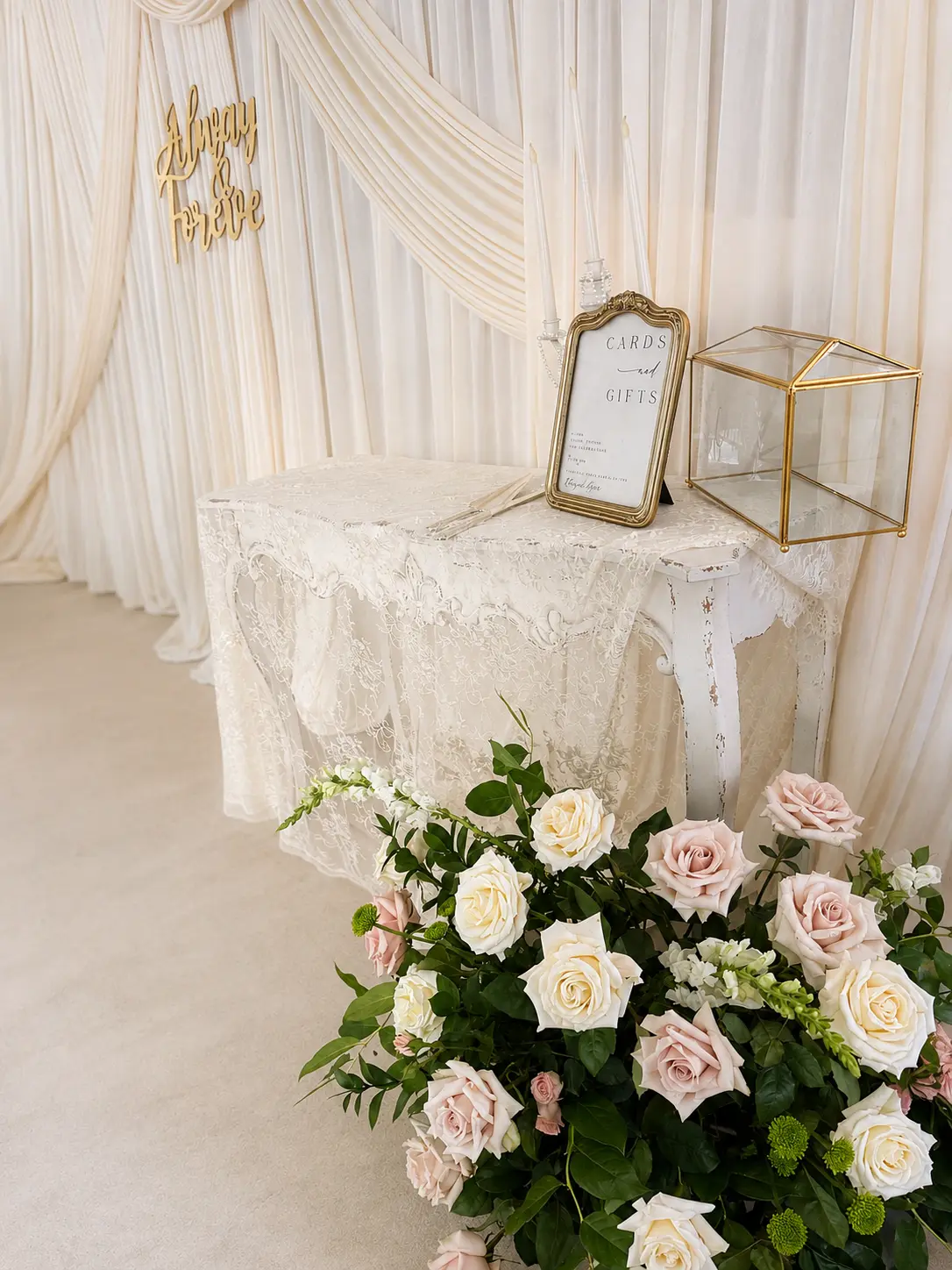 Cards and gifts table with lace linen, gold frame and ivory and blush rose ground arrangement